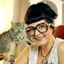 Kate Benjamin holding a kitten and looking at the camera